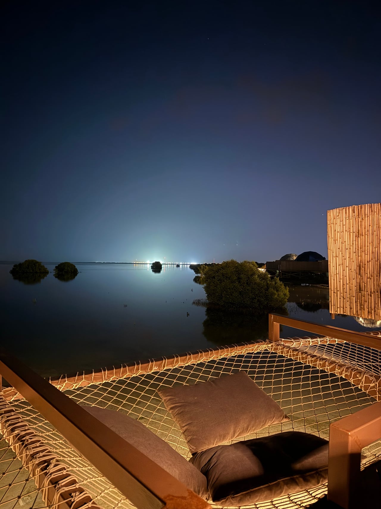 A stilted suite reflected in the lagoon at night