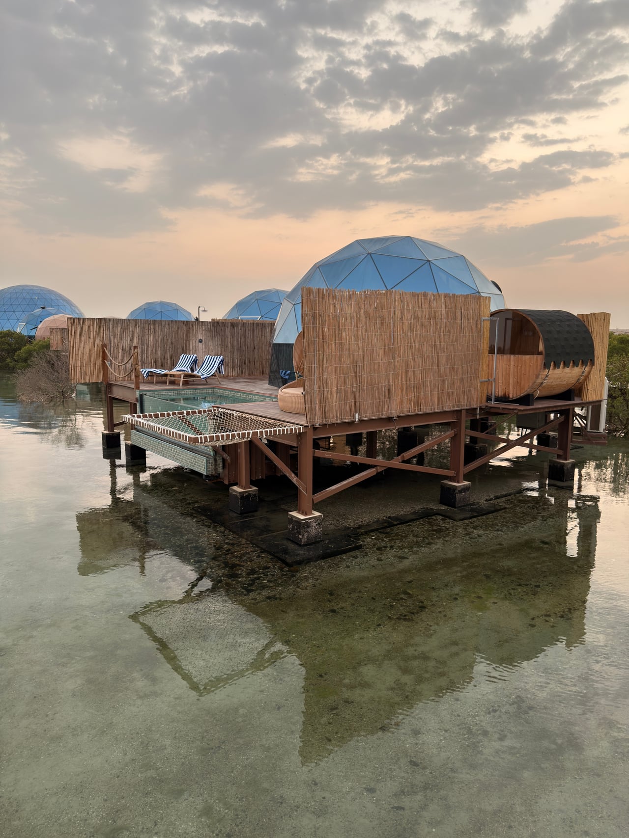 A glass-domed LuxeGlamp suite raised on stilts over the mangrove lagoon