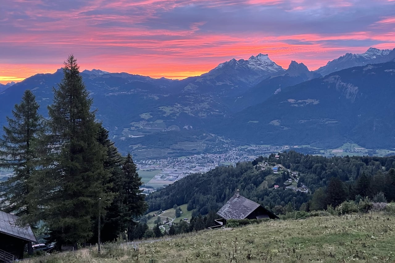A pink alpine sunrise over the Dents-du-Midi and the Rhône valley, seen from Whitepod Original